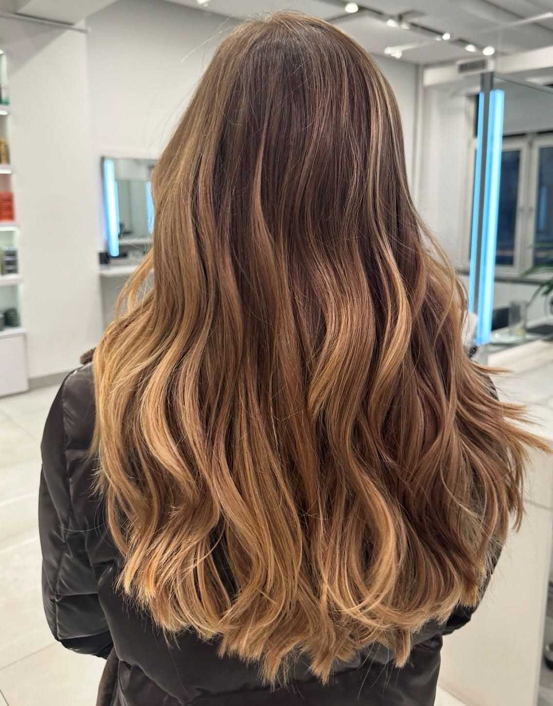 Wavy, golden-brown hair styled for a salon visit, viewed from behind.