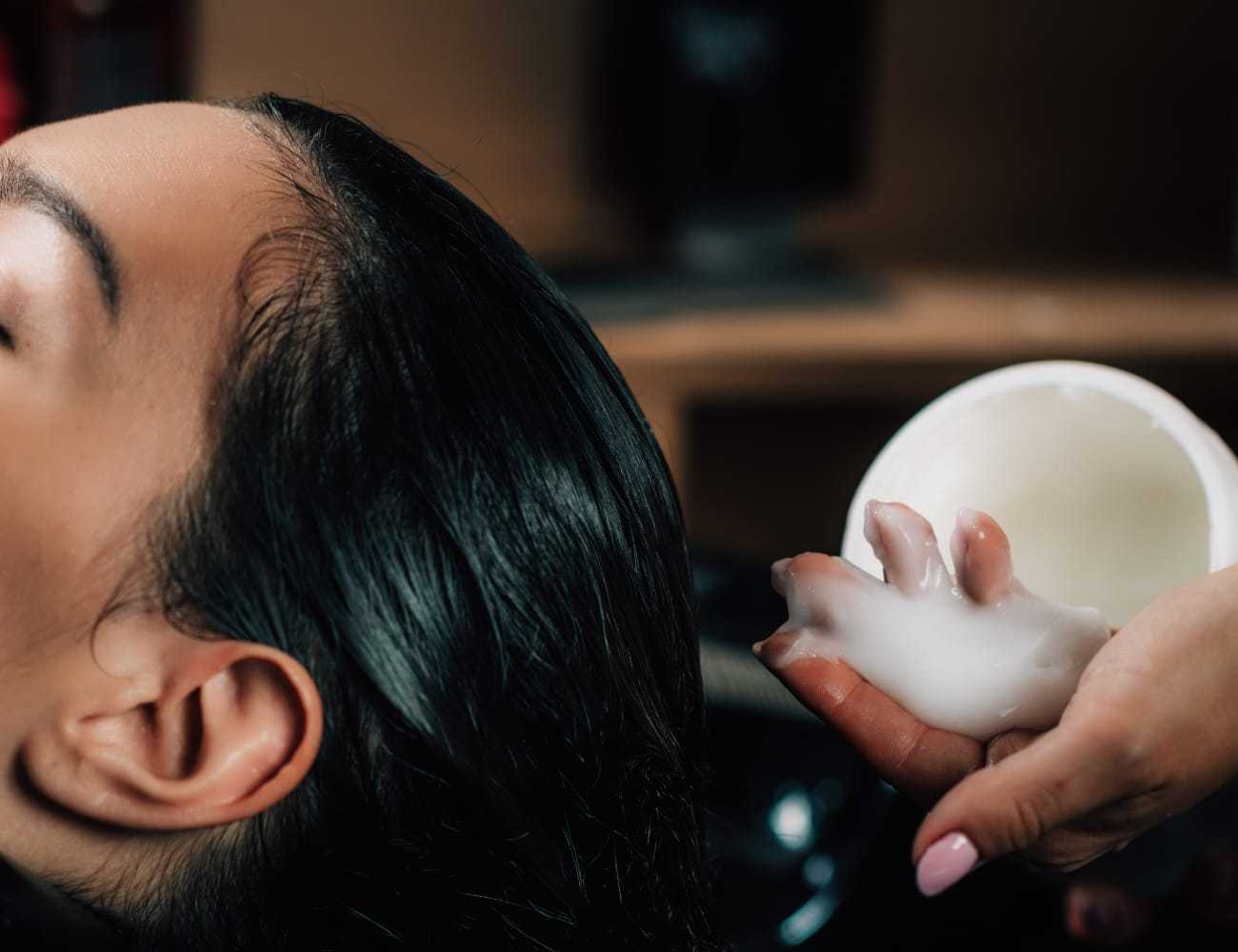 Hair treatment applied to wet hair in a salon setting.